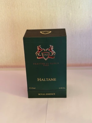 Parfums de Marly Haltane 125ml - Lyxig parfym från Parfums de Marly, modellen Haltane. Flaskan rymmer 125 ml och kommer i en elegant mörkgrön kartong med gulddetaljer och emblem med två hästar. Royal Essence-serien, Eau de Parfum. Perfekt för dig som gillar exklusiva dofter.