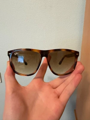 Ray-Ban Boyfriend Havana Glasögon - Solglasögon från Ray-Ban med brunmelerad båge och bruna tonade glas. Klassisk modell med logga på båda sidorna. Perfekt accessoar för att lyfta din stil. Bra skick, texten har gått bort lite.