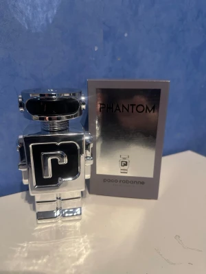 Paco Rabanne Phantom parfym - Phantom från Paco Rabanne är en futuristisk parfym i en cool robotformad flaska i silverfärgad metall och svart detalj. Doften är modern och flaskan sticker verkligen ut på hyllan. Perfekt för dig som gillar unika och snygga designer. Helt ny 100ml kvar i flaskan