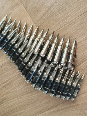 Bälte med silverfärgade patroner - Coolt bälte designat med silverfärgade patroner och svarta detaljer. Perfekt accessoar för dig som vill sticka ut och addera en edgy touch till din outfit. Bältet har en unik och tuff look som drar blickarna till sig. Går att göra kortare. Annonsen finns ute på flera sidor! 