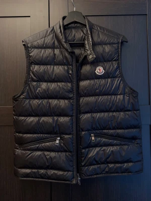 Moncler Gui Väst - Riktigt schysst gui väst i storlek 2-S/M. Självfallet äkta! Passar dig mellan 170-180cm. Nypris ligger på ca 9299kr. Västen har inga defekter alls! Perfekt till sommaren som extra lager! Bara att kontakta vid funderingar!🌟