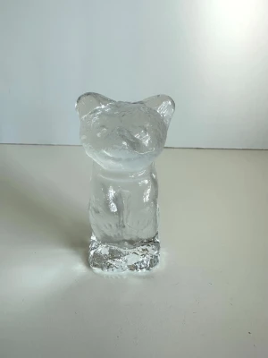 Björn-figur i klar glas - Unik björn-figur i klarglas. Stilren strukturerad yta som ger den ett isliknande utseende. 10cm hög, 4cm bred. Härlig inrednings-detalj som passar till det mesta, på bordet, i hyllan, på skåpet, varsom. Mycket gott skick, som ny!
