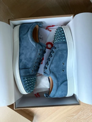 Christian Louboutin skor  - Helt nya Christian Louboutin skor junior spike. Storlek 41,5, färgen är blå/mörkblå. Allt og ingår. Perfekt inför vardag och fest! Skambud undanbes. Hör av er vid eventuella frågor. OBS! Replacement box. 