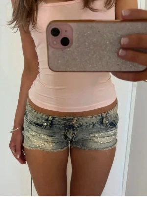 Lågmidjade shorts med pärlor - Såå fina blå slitna lågmidjade vintage jeansshorts med pärlor! midjemått rakt över: 42. Jag är 168 och det är mina bilder, köp via köp nu direkt eller Swish, kvar tills markerad som såld 💖 står ingen storlek men passar m/l