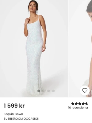 Vit glittrig långklänning Bubbleroom - Supersnygg vit långklänning från Bubbleroom Occasion med smala axelband, öppen rygg och glittrigt paljettmaterial. Klänningen har en figurnära passform och knytning i ryggen som ger en elegant look. PERFEKT balklänning!!! Endast använd en gång