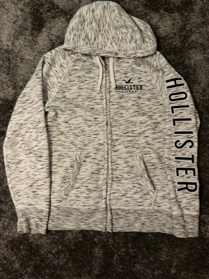 Vit och svart HOLLISTER zip-up - En riktigt fet Hollister zip-up. Använd ett fåtal gånger och är perfekt för en avslappnad men snygg outfit. Är öppen för prisförslag vid snabb affär. Skriv om det är något du undrar över!