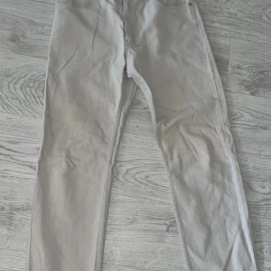 Vita raka jeans från Topaz - Snygga vita jeans från Topaz med raka ben och klassisk femficksdesign. Jeansen har coola detaljer som nitar och en liten etikett med texten 'Rocks' vid fickan. Perfekta för dig som gillar en clean och stilren look. priset är diskuterbart ❤️✅👌💋💤👾