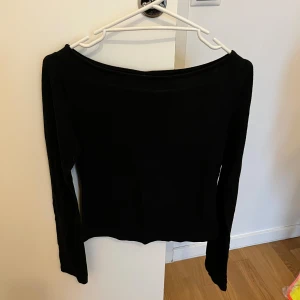 Svart  tunn topp - Säljer en svart offshoulder topp med lång ärm. Toppen är rätt genomskinlig. Något noppig. Från Nelly. Inga hål eller revor