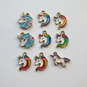 9st regnbåge färgade enhörning berlocker - Berlocker  Motiv: enhörningar  Färg: vit, regnbågefärgad, blå, lila. Guldfärgad baksida.  Skick: oanvänd, har enbart legat i en låda. Då de ej kom till användning.  Kul att använda till pyssel, smyckestillverkning eller bara sätt på ett halsband eller armband. #enhörning #unicorn #berlock #pyssel #smyckestillverkning #sverige #pärlor
