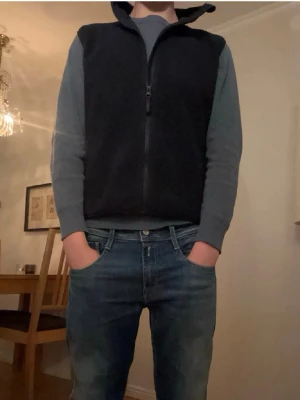 Svart dunväst med dragkedja - Snygg marinblå fleeceväst  med hel dragkedja framtill. Västen har en enkel och stilren design utan synliga loggor eller detaljer. Perfekt att bära över en tröja för extra värme. Materialet ser ut att vara mjukt och lätt vadderat.