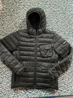 Barbour quiltad jacka - oliv/mörkgrön - Barbour International Ouston Quilted Jacket (puffer).  Lightweight dunjacka. Passar bra på vår och höst. Säljer pga för liten