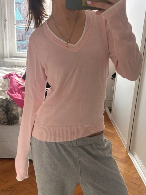   stickad ljusrosa tröja med v-ringning - Ljusrosa stickad tröja från esprit med v-ringad hals och långa ärmar. 