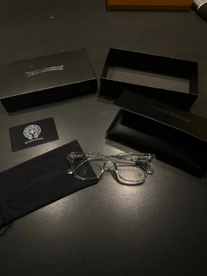 Transparenta glasögon  - Säljer ett par stilrena solglasögon med transparenta bågar och klassisk form. Glasögonen har detaljer i silver och kommer med originalfodral och box. Perfekt för dig som vill ha en unik accessoar.