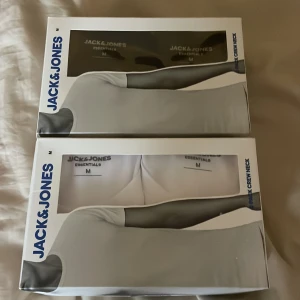 Jack & Jones vita t-shirts 2-pack - Säljer två oöppnade 2-pack vita och/eller svarta t-shirts från Jack & Jones. Båda paketen är i storlek M. På mig som är 183cm lång och väger 74kg sitter tröjorna bra då jag jämför med en annan tröja jag själv äger fast i samma modell på bild 4. Bra investering med nya fräscha t shirts inför sommaren till ett bra pris. 299kr för båda boxarna. 179kr om man vill köpa en box separat. Hör av dig vid minsta fundering!💫