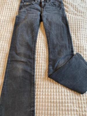 Mörk gråa jeans från Gina tricot - Snygga mörkblå bootcut jeans med klassisk femficksmodell och lätt slitna detaljer. Jeansen har normal midja och är tillverkade i mjuk denim med lite stretch för extra komfort. Perfekta till sneakers eller boots. Sälger  pga för små. Pris kan diskuteras🫶🏻🫰🏻