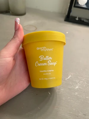 Butter Cream Soap Vanilla Creme - Butter Cream Soap från Earth Rhythm i doften Vanilla Creme med vaniljolja. Kommer i en gul plastburk med lock och medföljande vit spatel för enkel applicering. Perfekt för dig som vill ha en lyxig och återfuktande rengöring med härlig vaniljdoft.