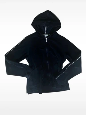 Burberry Svart velour hoodie med dragkedja - Snygg svart hoodie i ’strävt’ velour ifrån Burberry med dragkedja framtill och huva. Hoodien har långa ärmar med diskreta ränder längs sidorna och en avslappnad passform. Perfekt för en chill och trendig look.