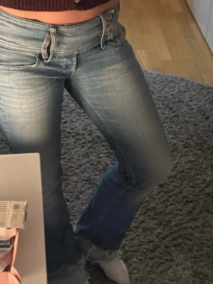 Lågmidjade Diesel Jeans - Säljer ett par ljusblå bootcut jeans från Diesel. Jeansen har låg midja, dubbla knappar. Storlek w29 och L30💕Köpta på Vinted tidigare ägare har sytt på förlängning men går att ta bort ( se sista bilden)🥰