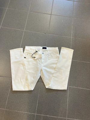 Vita jeans från tiger of sweden W31 L30 - Snygga vita slimmade jeans från tiger of sweden med klassisk femficksmodell och smal passform. Jeansen har bälteshällor, knappgylf och är tillverkade i ett stretchigt bomullsmaterial för extra komfort. Perfekta för en clean och fräsch look.