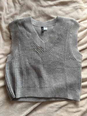 Stickad väst grå XS- oversized fit H&M - Stickad väst i grå färg med en lätt V-ringad urringning – perfekt för lager-på-lager outfits 🤍  Passar jättebra över en skjorta eller tröja för en stilren och trendig look. Modellen är lite oversized/loose vilket ger ett avslappnat fall.  Från H&M, storlek XS. I princip nyskick (utan prislapp).  Jag är 170 cm och brukar ha storlek S/M – denna sitter lite mer loose på mig ✨  En enkel bas som verkligen lyfter en outfit och funkar året runt.