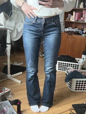 Blå bootcut jeans från Tommy Hilfiger - Super snygga Tommy Hilfiger jeans i mörk blå. Bootcut och midrise. 41cm i midjan och långa på mig som är 168 cm. Beställde dessa och de var tyvärr för stora. Inga märken som tyder på användning.