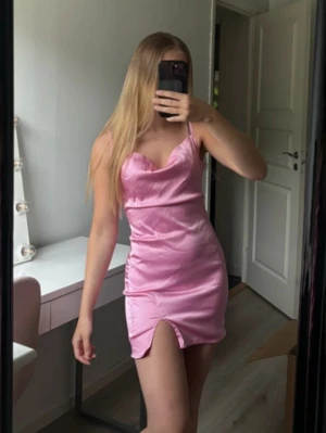 Rosa kort satinklänning - Använd ett tillfälle, som ny. Reglerbara band och dragkedja, liten slits i sidan. Superfin rosa färg !