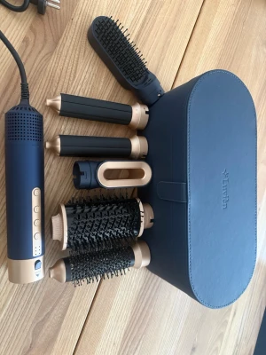Lurian Multi-Styler hårstyler set - Helt oanvänd!Snyggt multi-styler set från Lurian i marinblått och guld. Innehåller flera utbytbara tillbehör som rundborstar, locktänger och fönmunstycke. Kommer med en matchande förvaringsväska i konstläder. Perfekt för att skapa olika frisyrer hemma.