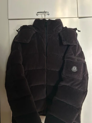 Brun manchester pufferjacka Moncler - Mörkblå pufferjacka från Moncler i mjuk manchester. Jackan är endast använd en säsong så i nyskick. Sjukt fint Manchester material som ger en exklusiv och lyxig känsla. Jackan är i storlek 4 vilket motsvarar M/L. Kvitto finns dessvärre inte så kan inte garantera äkthet till 100%, däremot medföljer moncler påsen jackan kom i, alla tags osv. Pris går att diskutera därmed jag inte kan garantera något