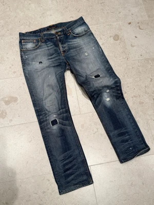Nudie jeans - Säljer ett par snygga nudie jeans med snygga slitningar. De är i bra skick och har inga skador eller fläckar. W33 L32.  Pris 1300. Fjärde bilden är innerbenslängd👍