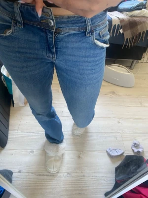 Blå raka jeans med låg midja - Säljer ett par klassiska blå jeans med låg midja och raka ben. Jeansen har fem fickor och stängs med dragkedja och knapp. Perfekta till vardags och passar till det mesta. Materialet är denim i bomull.. Den översta knappen har låsbar men jag viker bara ner de. Och det syns inte då.💕