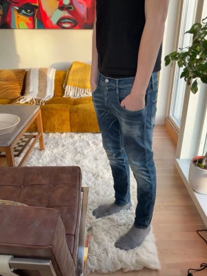 Blå slim fit jeans med slitningar - Säljer ett par blå slim fit jeans med snygga slitningar och tvättade detaljer. Jeansen har klassiska fem fickor och normal midja. Perfekt för dig som gillar en modern och avslappnad look. Slitning visas på bild 5 (ej hål utan bara en slitning). Hör av dig vid frågor eller funderingar💎😇