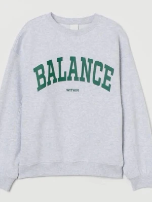 Grå sweatshirt  - Säljer en grå sweatshirt med texten BALANCE i grönt och mindre texten WITHIN under. Tröjan har rund hals, långa ärmar och ribbade muddar. 