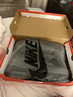 Nike Air Max 95 grå sneakers - Nike Air Max 95 sneakers i helgrå färg med mesh och syntetpaneler. Klassisk chunky sula och ikonisk design med synlig Air-enhet. Skorna har gråa skosnören och detaljerade sömmar för en sportig look.