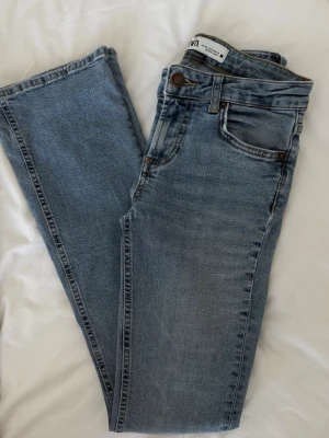 Blå jeans från Zara - Snygga ljusblå jeans från Zara med klassisk femficksmodell. Jeansen har använts ett par gånger men har tyvärr blivit lite korta på mig som 1,67cm lång. Jeansen är otroligt bekväma och är både lågmidjade och normalmidjade beroende på hur man själv ser på dem! 🤍