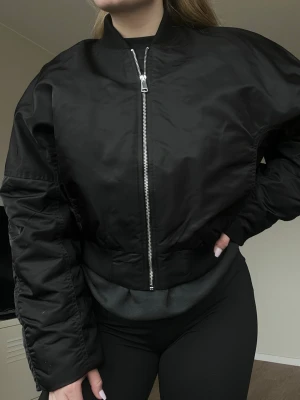 Y2K boxig clean bomberjacka Gina Tricot stl S - nyskick - Boxig bomberjacka från Gina Tricot, storlek S. Knappt använd och i superfint skick!  Perfekt för en clean Y2K-look – tänk low waist jeans, babytee och chunky sneakers. Den ger verkligen den där lite oversized, coola 00-talskänslan. Fler bilder finns om så önskas!