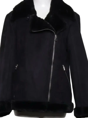 Svart pälsjacka med dragkedja  - Stilren svart pälsjacka med sned dragkedja och bred krage i fuskpäls. Jackan har två fickor med dragkedja och mjuk pälsdetalj vid ärmslut och nederkant. Perfekt för kalla dagar och ger en cool look. Ej använd då den var för lite 