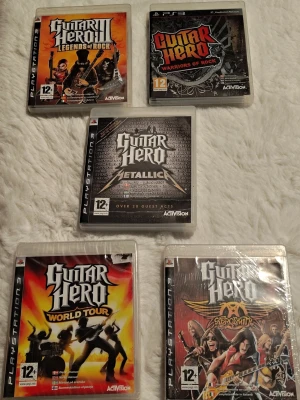Guitar Hero PS3 spelpaket - Säljer en samling Guitar Hero spel till PS3. World Tour och Aerosmith är oöppnade. De andra 3 spelen säljes i befintligt begagnat skick. Skivorna har något enstaka fingeravtryck men fungerade fint när jag testade dom, inget hack eller lagg.