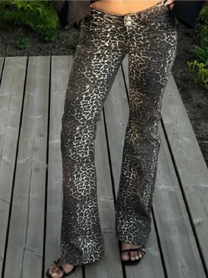 Leopardmönstrade bootcut jeans från Nelly - Säljer ett par snygga leopardmönstrade bootcut jeans med låg midja. Jeansen har klassisk femficksmodell och stängs med dubbel knapp och dragkedja. Materialet är stretchigt och bekvämt, perfekt för dig som vill sticka ut med ett djurmönster. Endast använda ett fåtal gånger och inga defekter💕💕. Bara att be om fler bilder med byxorna på och de är i storlek EU 36. Passar mig som brukar ha 25/32.💕🥰