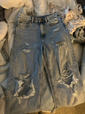 Ljusblå ripped mom jeans - Säljer ett par ljusblå mom jeans med stora slitningar och hål på både lår och knän🌺🌺