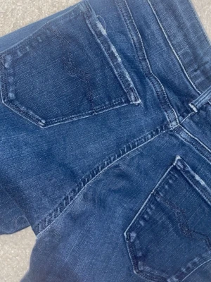 Replay jeans w26 - Säljer ett par mörkblå slim fit jeans med klassiska fem fickor och snygga slitningar. Jeansen har en smal passform och är tillverkade i ett mjukt denimtyg som sitter skönt. Perfekta för dig som gillar en stilren och modern look.