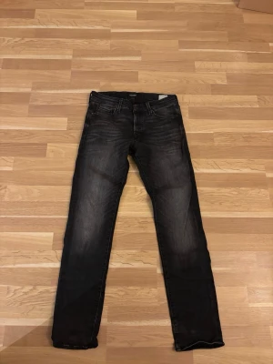 Svarta slim jeans från Jack & Jones - Snygga svarta slim fit jeans från Jack & Jones, modell Glenn. Jeansen har klassisk femficksdesign, normal midja och raka ben. Materialet är stretchigt denim som ger en bekväm passform. 
