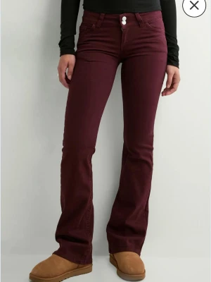 Vinröda bootcut jeans med låg midja - Snygga vinröda bootcut jeans med låg midja och klassiska fickor. Jeansen har utsvängda ben och stängs med två knappar framtill. Perfekta för dig som vill ha en trendig och bekväm look. från nelly använda 2-3 gånger max. föll inte mig i smaken 