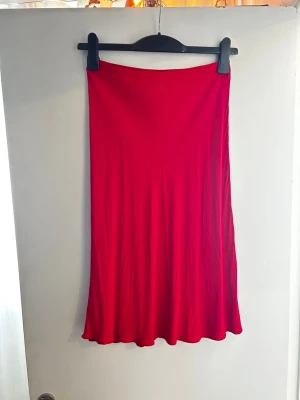 Kjol midi - En knälång, utställd kjol i crêppad, vävd viskos med hög midja med dold resår. Ca 70.5 cm lång. Bortklippt tagg, men endast testad och och sen inte använd.