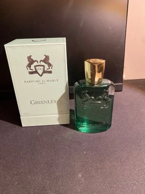 Parfums de Marly Greenley 125ml - Greenley från Parfums de Marly är en exklusiv parfym i en elegant grön glasflaska med guldfärgat lock. Flaskan har ingraverade hästar och levereras i en stilren ljusgrön kartong med bronsdetaljer. Volymen är 125 ml. Kvitto finns och en sephora tag