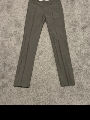 Tiger of Sweden Kostymbyxor - Ett par gråa Tiger of Sweden kostymbyxor i bra skick. Inga tecken på användning förutom lappen där texten har försvunnit.  W30 / L30  Pris kan såklart diskuteras :)