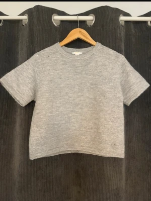 Grå stickad T-shirt  - Grå stickad T-shirt. Storlek 158/164