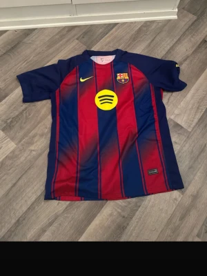 FC Barcelona matchtröja Nike - Säljer en FC Barcelona matchtröja från Nike i klassiska blå och röda vertikala ränder. Tröjan har klubbmärke, Nike-logga och Spotify som sponsor framtill samt UNHCR-logga bak. Tillverkad i lätt och ventilerande material, perfekt för fotbollsträning eller match.