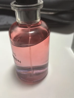 Louis Vuitton City of Stars parfym - Lyxig parfym från Louis Vuitton, City of Stars, i en elegant rund glasflaska med rosa tonad vätska. Flaskan har silverfärgad hals och svart lock. Perfekt för dig som vill ha en exklusiv doft med snygg design på hyllan.