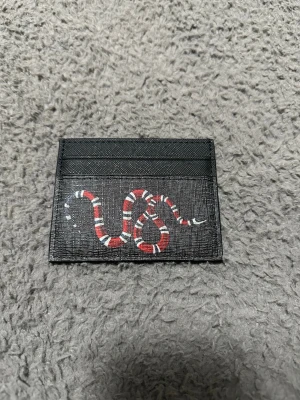 Plånbok  - Säljer en fin plånbok med orm logga på. Väldigt fin och smidig! Priset är inte hugget i sten!