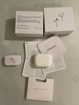 AirPods Pro trådlösa hörlurar - Säljer ett par vita AirPods Pro med laddningsetui. Hörlurarna har en stilren och kompakt design, silikonproppar för bra passform och brusreducering. Allt originaltillbehör och förpackning medföljer. Perfekta för musik, samtal och träning.